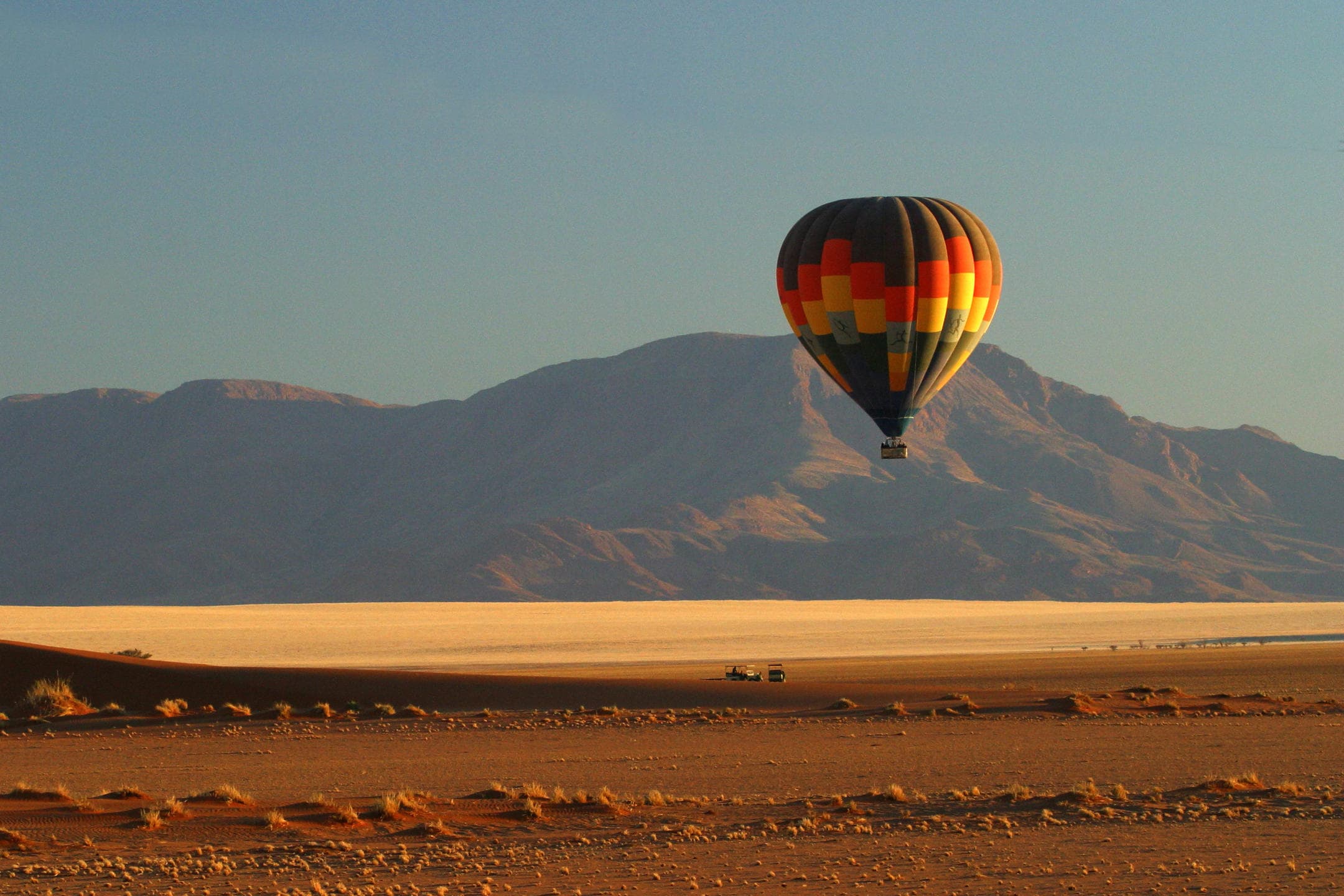 Hot air balloon drifting over the Namib Desert at Wolwedans Plains Camp.