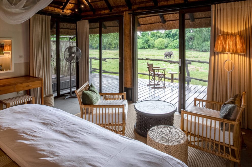 A luxury bedroom with a private deck overlooking the African wilderness at Mfuwe Lodge, Zambia.