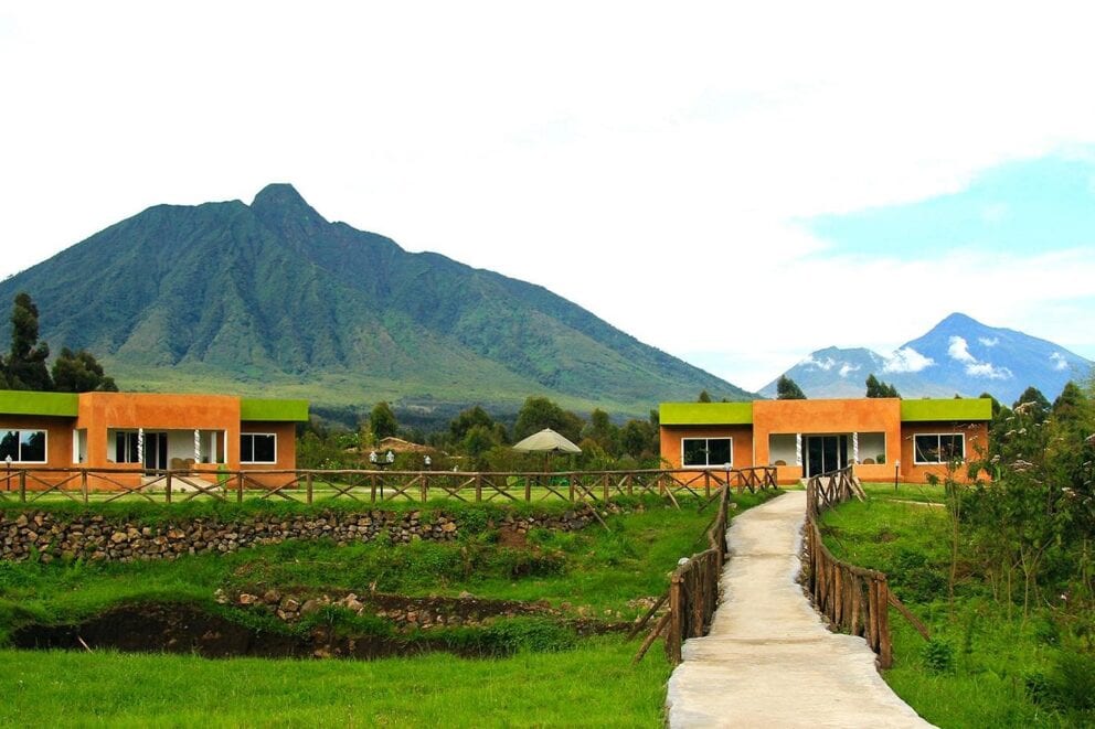 A path leading to orange chalets with a mountain in the background