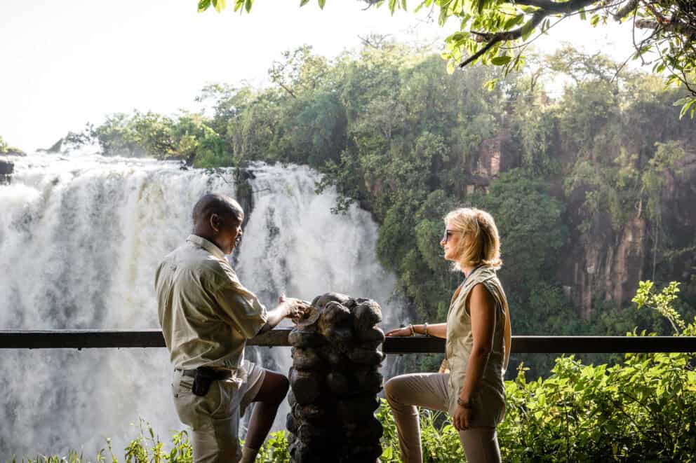 A guide and tourist standing along the Victoria Falls pathway at Sussi & Chuma Lodge, Zambia.