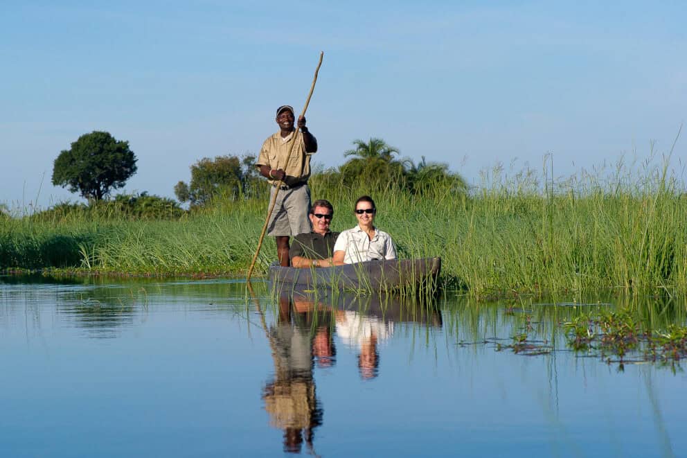 A couple on a mokoro boat ride through the floodplains of the Okavango Delta at Jacana.