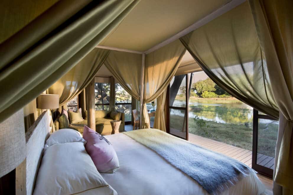 Kind sze bed in a safari camp overlooking a waterway in the Okavango Delta in Botswana