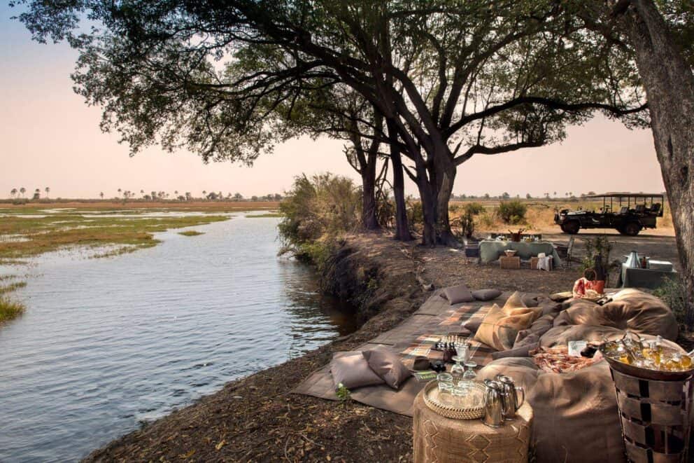 A bush picnic set up along a scenic waterway at Sandibe Okavango Safari Lodge, Botswana.