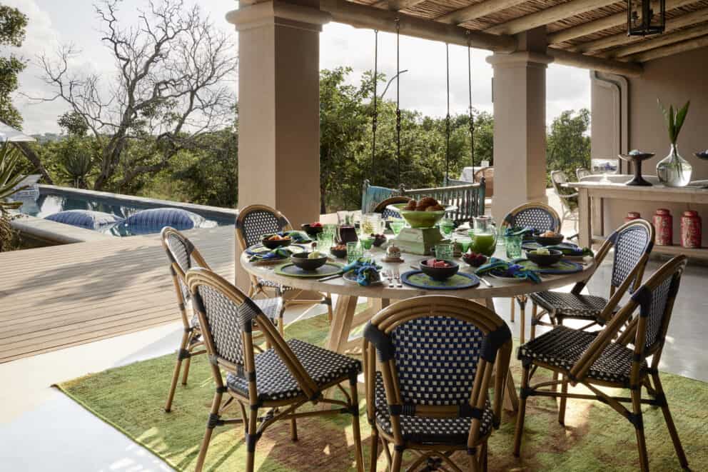 View of a table setting overlooking the pool and surrounding bush at Royal Malewane, South Africa.