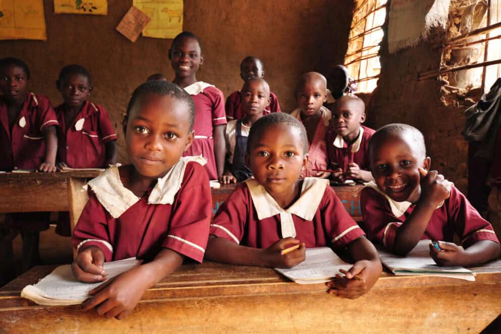 Children in school uniform in a classroom in Uganda.