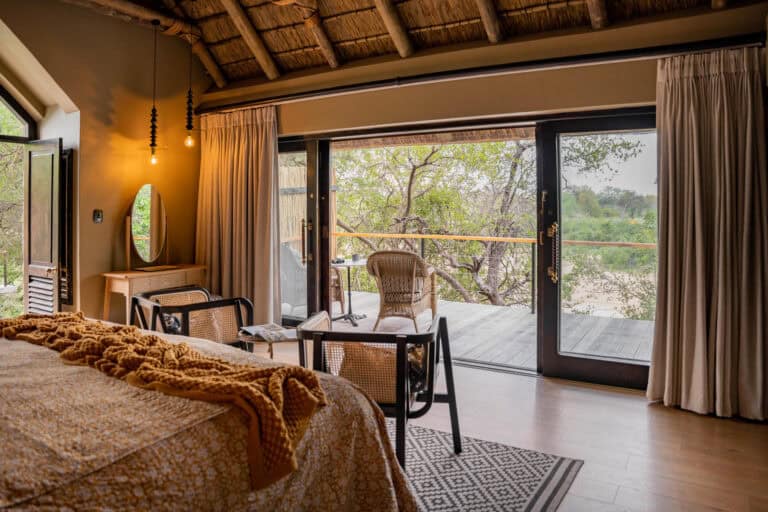View of the bedroom and private balcony overlooking the African Bush at Thornybush Game Lodge, South Africa.