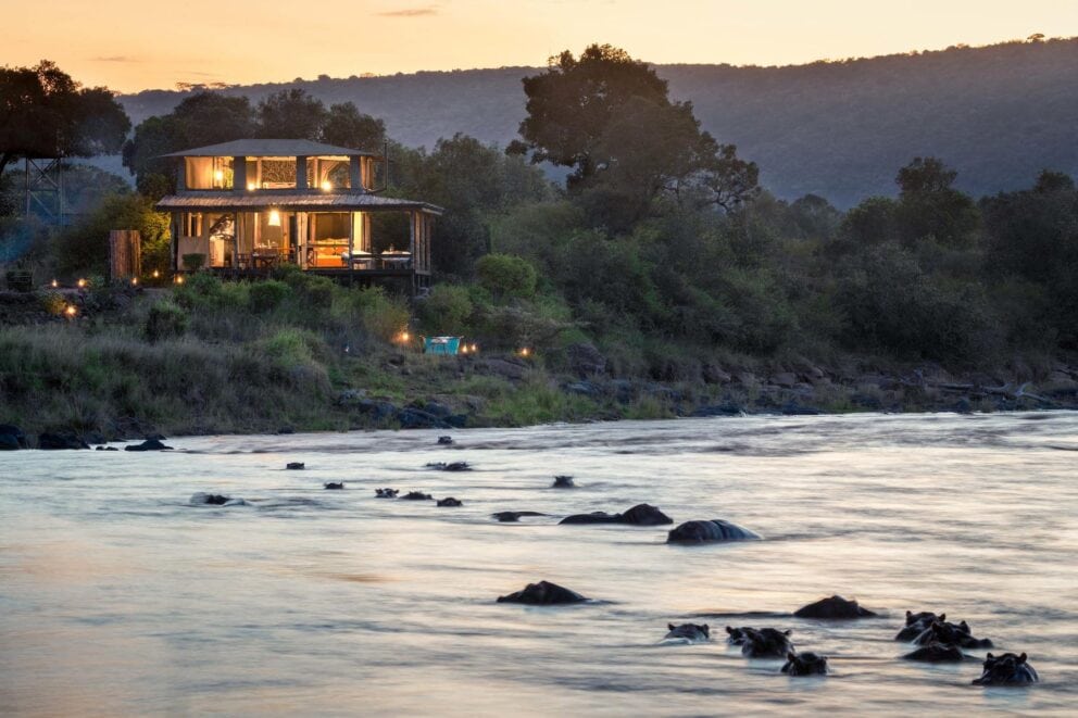 View of Serian’s Kimya Kimya camp from the river filled with hippos floating by in Kenya.