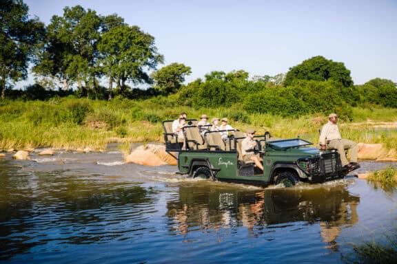 Safari vehicle driving through a river in Sabi Sand Game Reserve