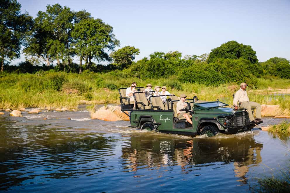 Safari vehicle driving through a river in Sabi Sand Game Reserve
