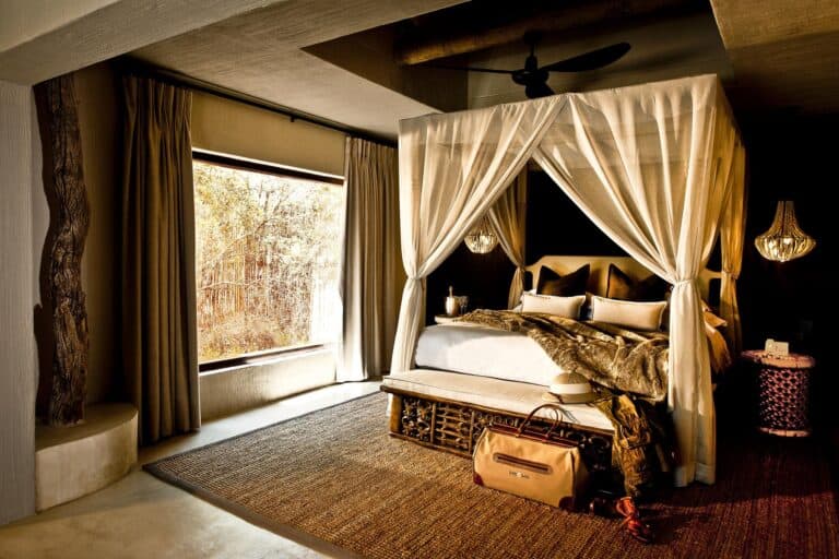 Interior of the luxury bedroom suite, featuring a canopied bed with luxury insect netting at Sabi Sabi Bush Lodge, South Africa.