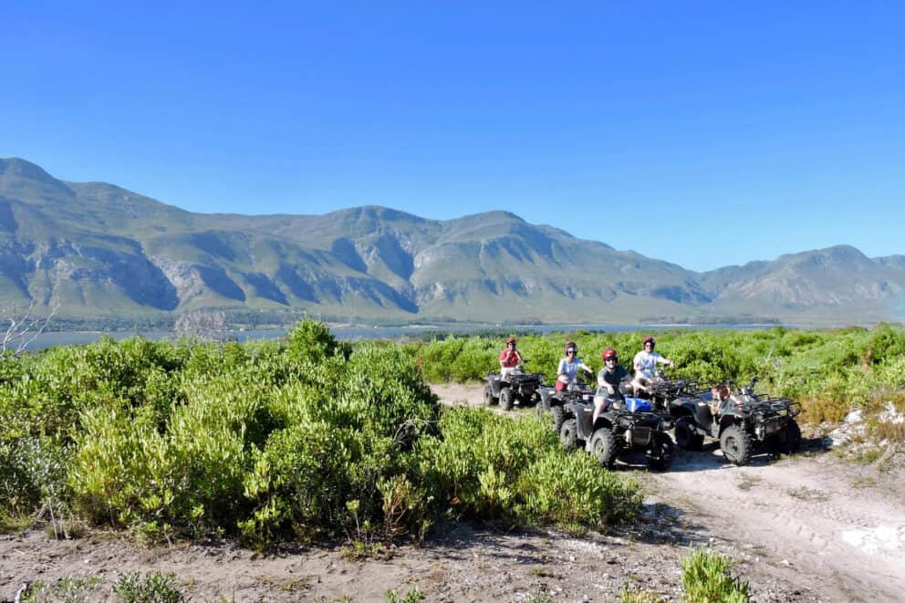 Tourists quad biking along the sandy dunes at Mosaic Lagoon Lodge, South Africa.