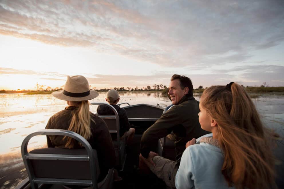 A family on a boat cruise at Vumbura Plains, Botswana.