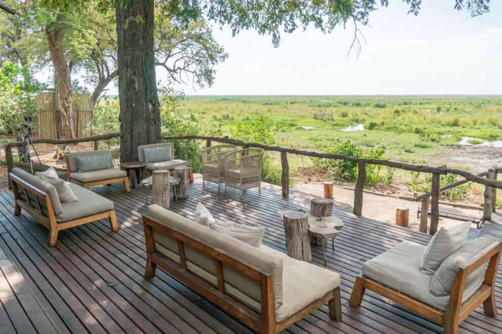 View of the Linyanti plains from the elevated wooden deck with comfy seating under ancient trees at Linyanti Ebony, Botswana.