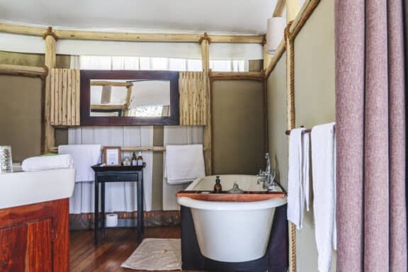 View of the bathroom at Dulini Anabezi, featuring a freestanding bath in Zambia.