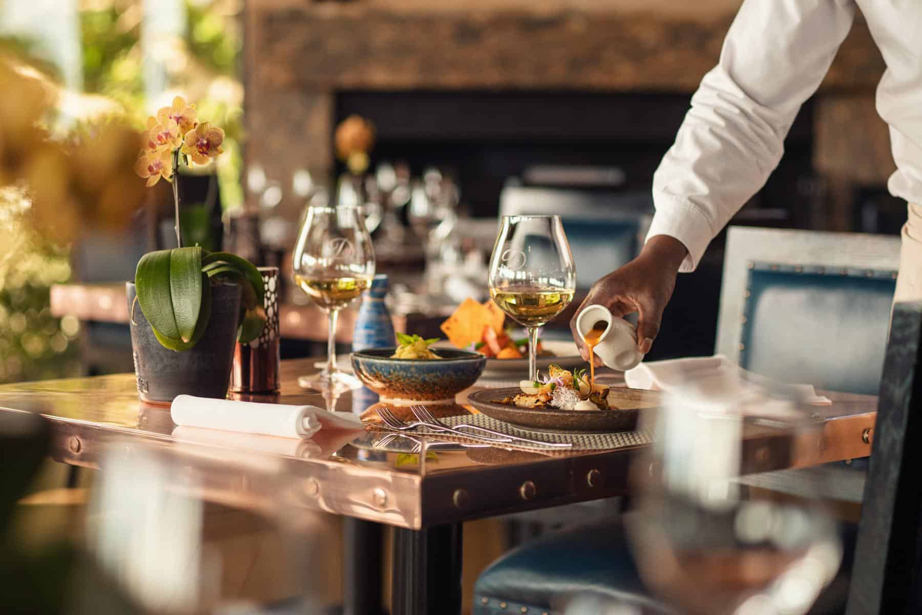 A table set with culinary dishes and wine at Delaire Graff Lodges & Spa, South Africa.