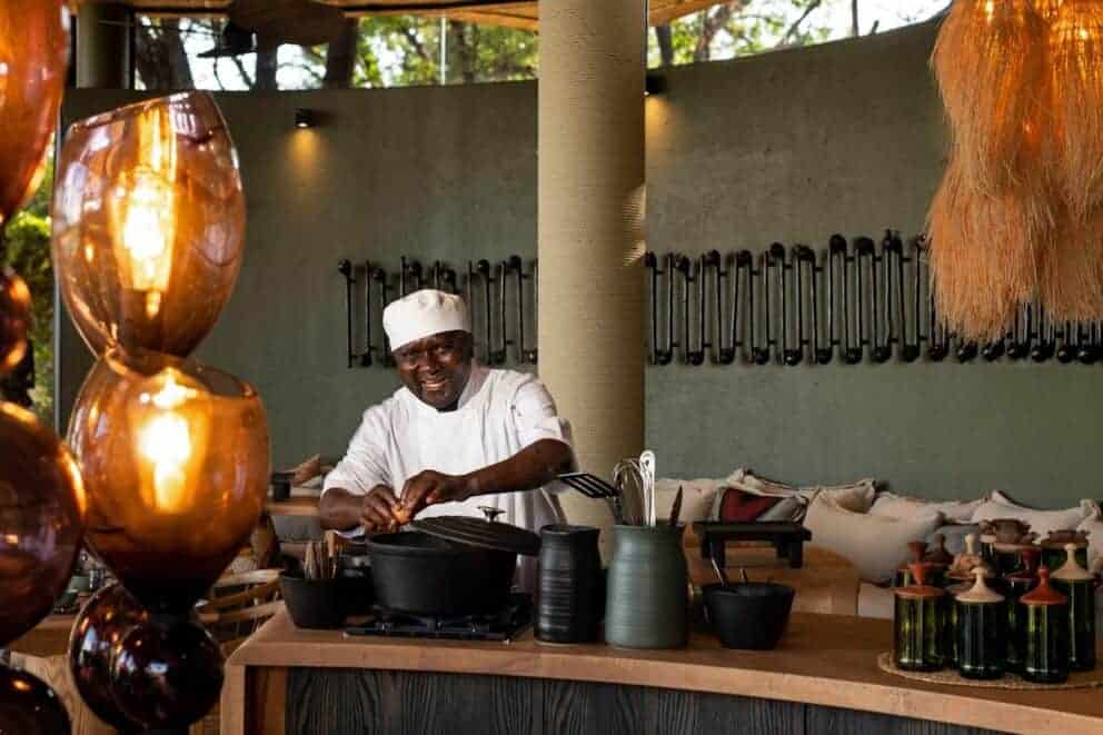 A chef cooking a meal in the interactive kitchen at Grumeti Serengeti River Lodge, Tanzania.