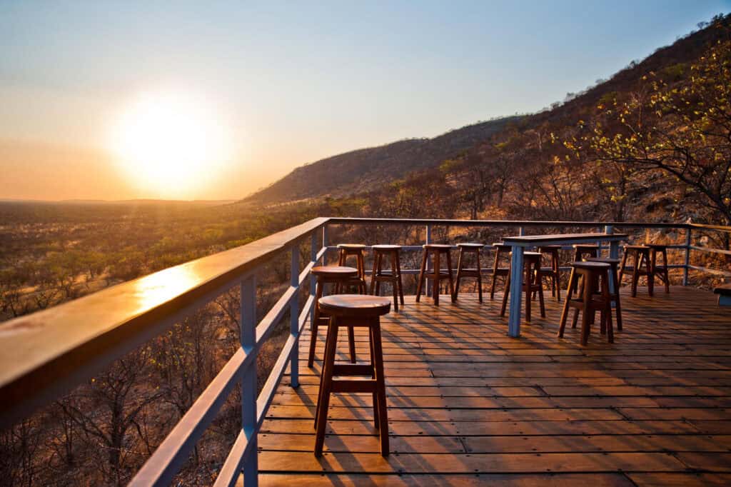 View of the desert landscape at sunrise from the elevated deck at Damara Mopane Lodge, Namibia.
