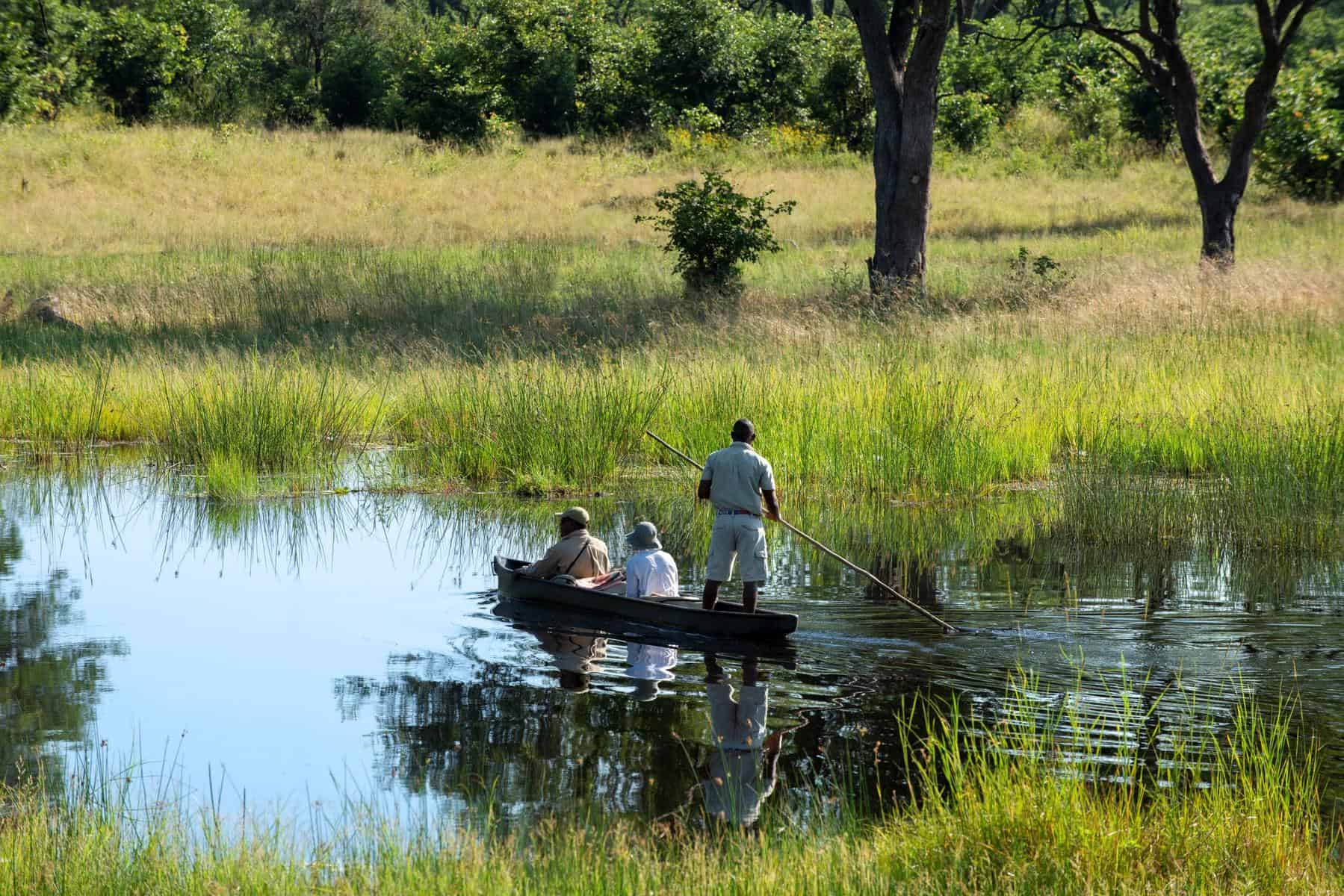 Guests on a guided mokoro ride through the water channels of the Khwai River at Khwai Leadwood, Botswana.