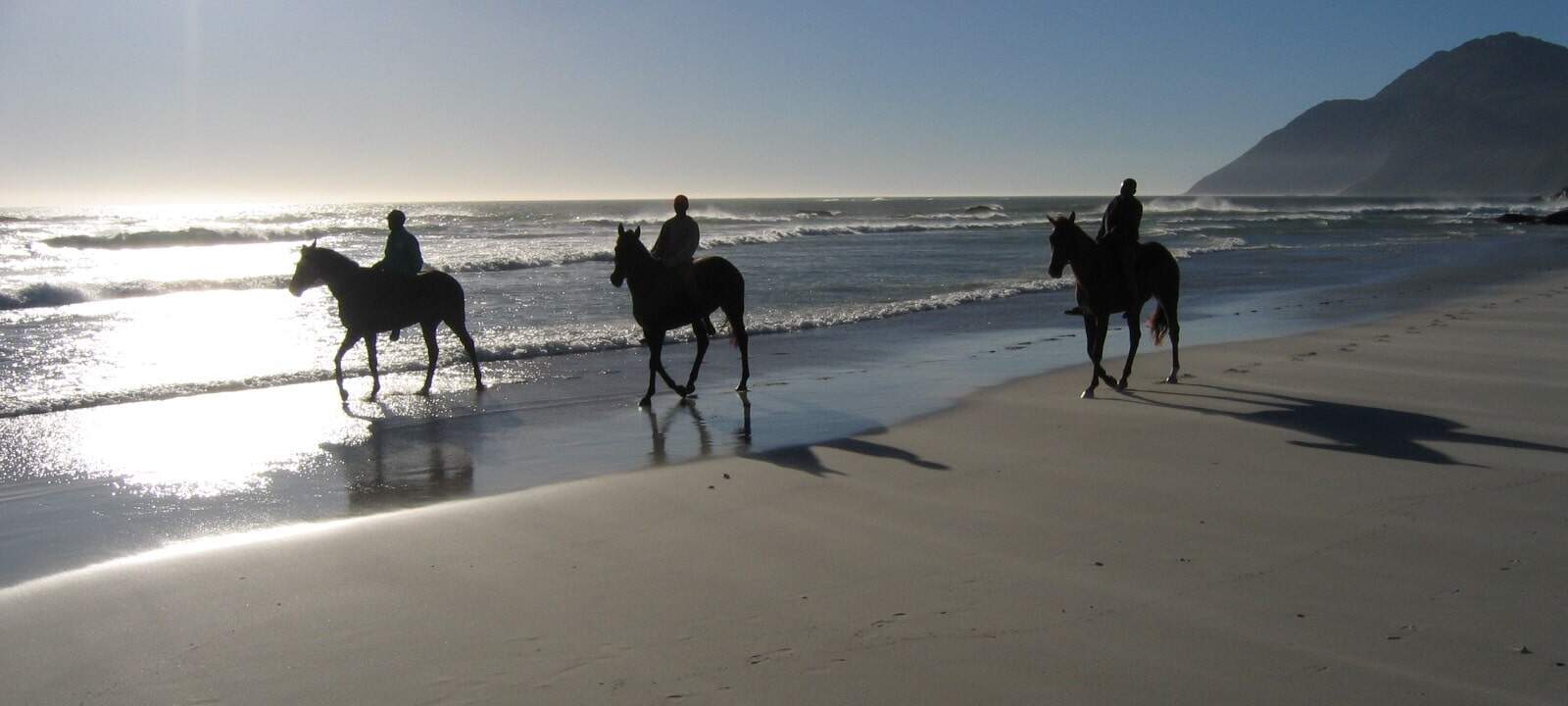 Riders on a horse riding safari on Noordhoek beach in South Africa
