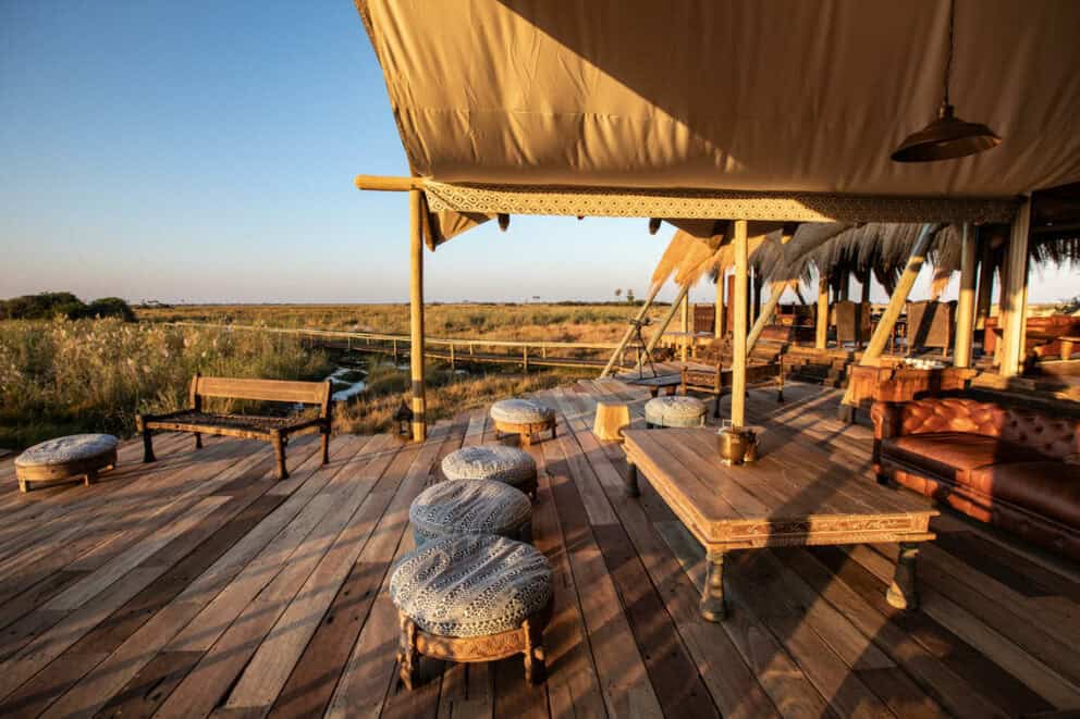 View of the bush from the wooden deck, featuring comfy seating and panoramic views at Selinda Camp, Botswana.