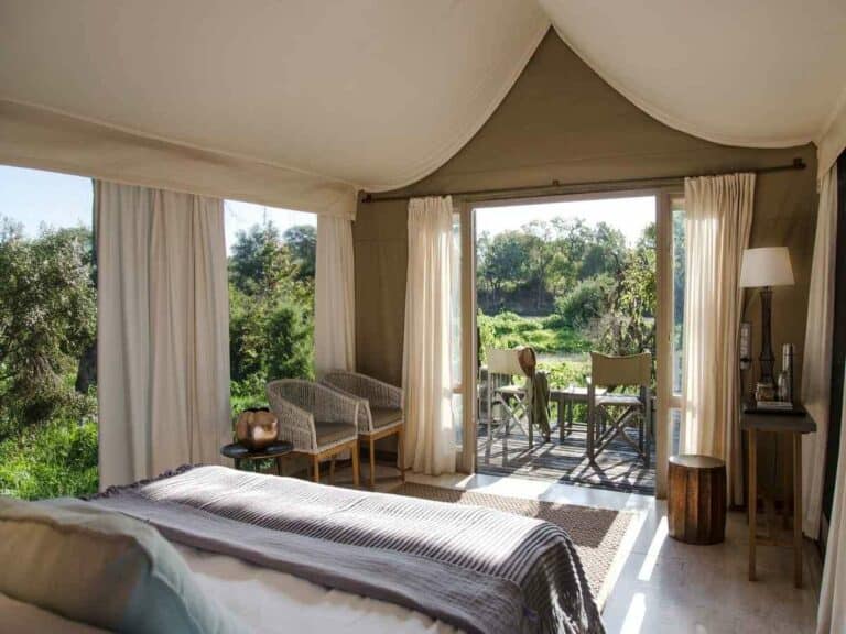 View from the bedroom, featuring a private deck overlooking the African bush at Simbavati River Lodge, South Africa.
