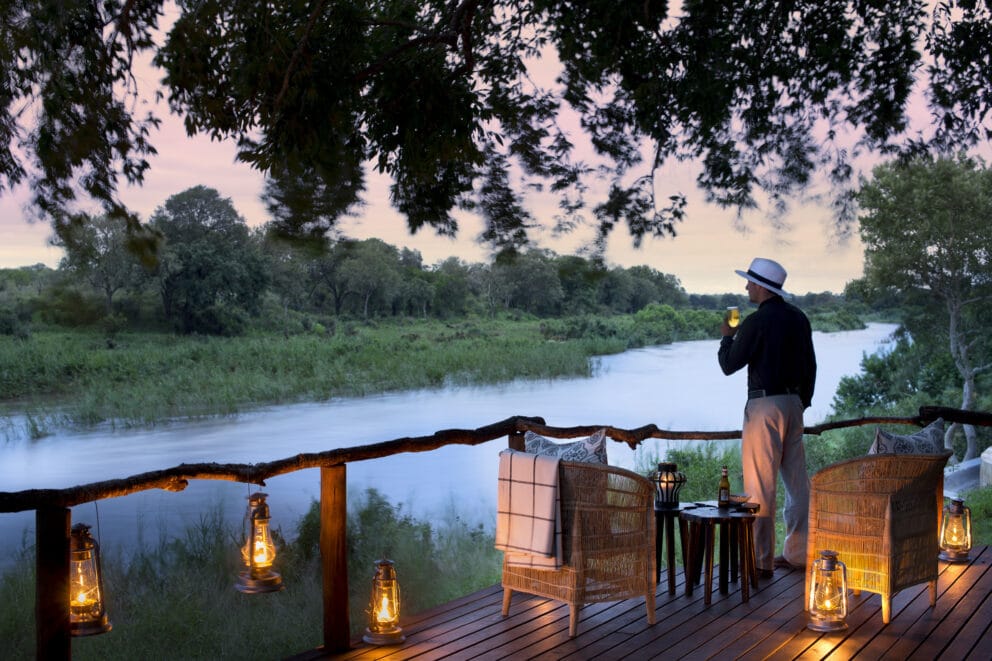 A guest admiring the view of the Sabie River from the elevated deck at Lion Sands Tinga Lodge, South Africa.
