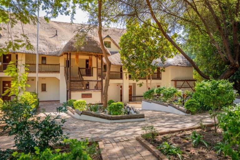 Exterior view of the room shaded by trees at Chobe Safari Lodge, Botswana.