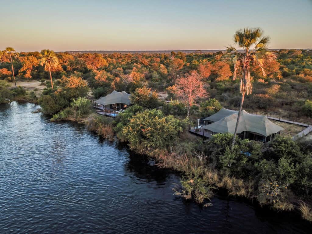 An aerial view of Old Drift Lodge surrounded by the Zambezi's emerald canopy.