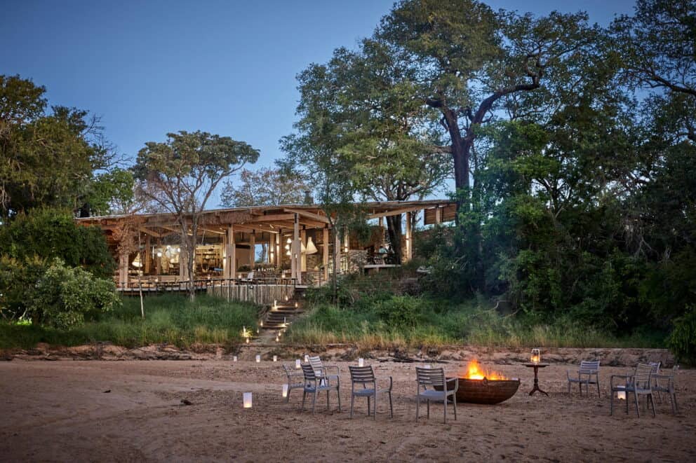 Exterior view of Saseka Tented Camp in Thornybush Game Reserve, South Africa, featuring a firelit boma at dusk.