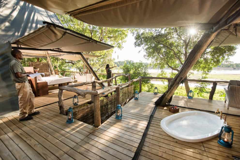 View of the tent interior, featuring a sunken bath and views of the Luangwa River at Shawa Luangwa Camp, Zambia.