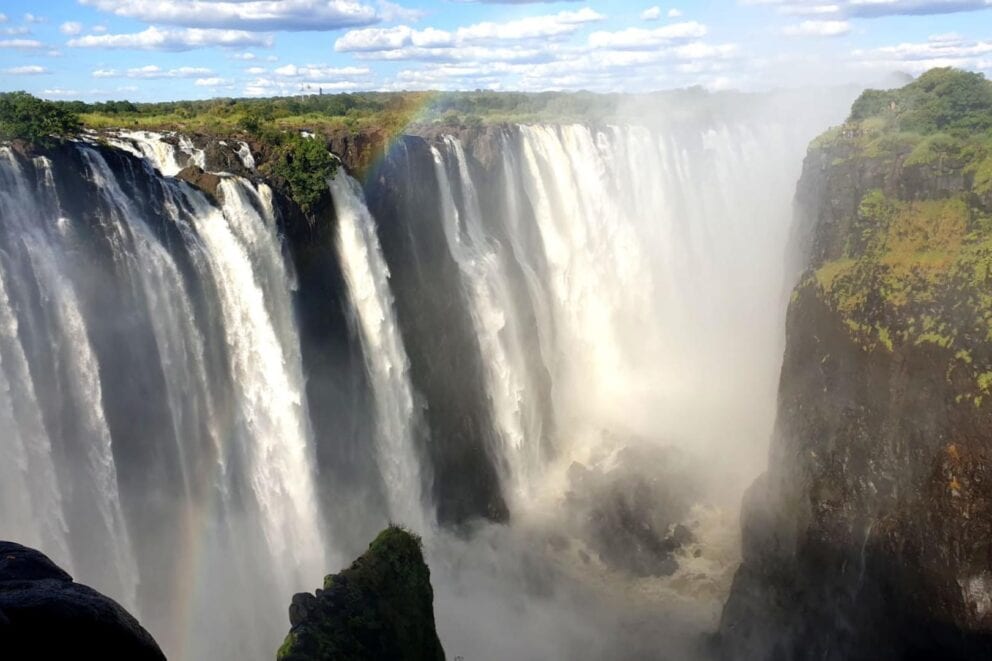 View of Victoria Falls with the water cascading down the edge. Chundu Island, Zimbabwe.