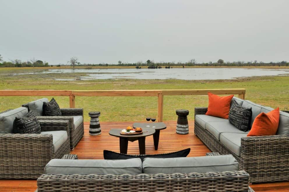 Sweeping views of the Kwikamba Pan from the elevated wooden deck, featuring comfy sofas at Nogatsaa Pans Lodge, Botswana.