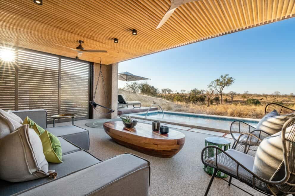 Luxury suite terrace, featuring cozy couches overlooking the pool and the wilderness beyond at Sabi Sabi Earth Lodge in the Sabi Sand Nature Reserve, South Africa