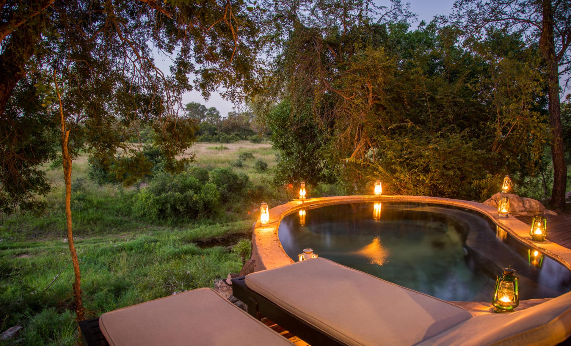 View of the bush from the plunge pool deck at dusk by candlelight in Kruger National Park