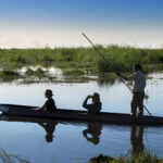 Guests on a guided mokoro ride along the waterways near Linyanti Bush Camp in the Linyanti Concession, Botswana.