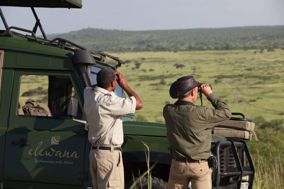 A tourist and guide looking through binoculars at Tarangire Treetops, Tanzania.