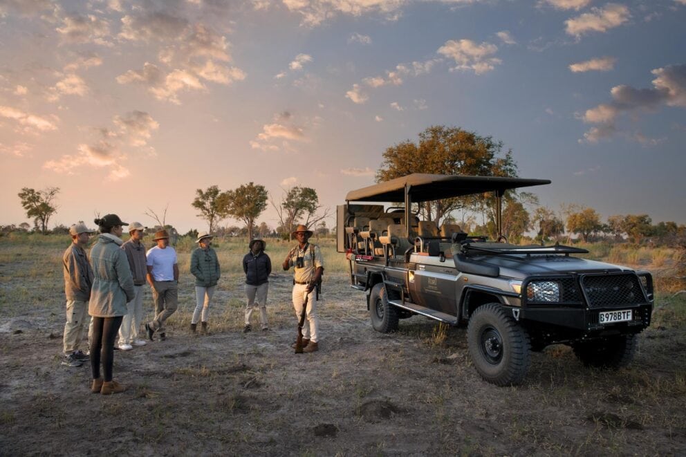 Travellers setting out of a game drive vehicle while on safari.