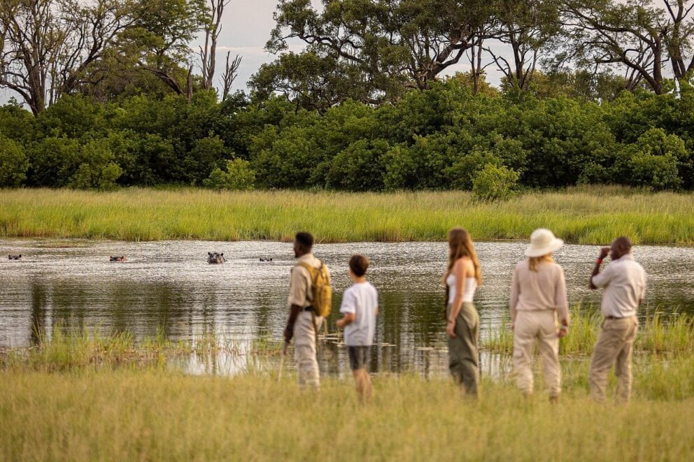 A group on a walking safari by a river | Photo credit: Feline Fields Vintage Camp