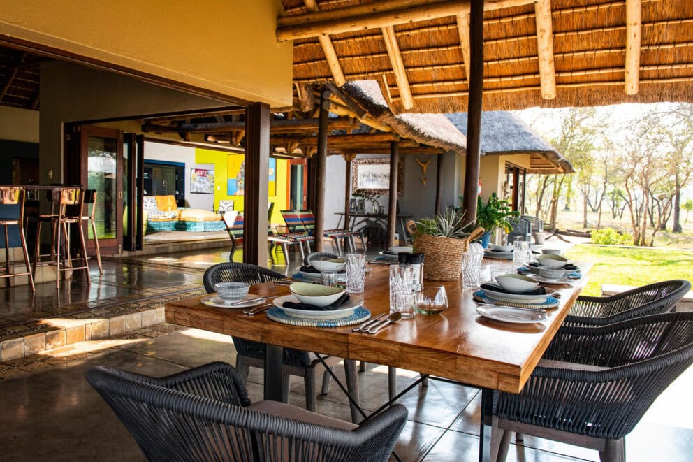 View of the open plan dining space with comfy chairs, with a view of the outdoors at Jaci's Sabi House.
