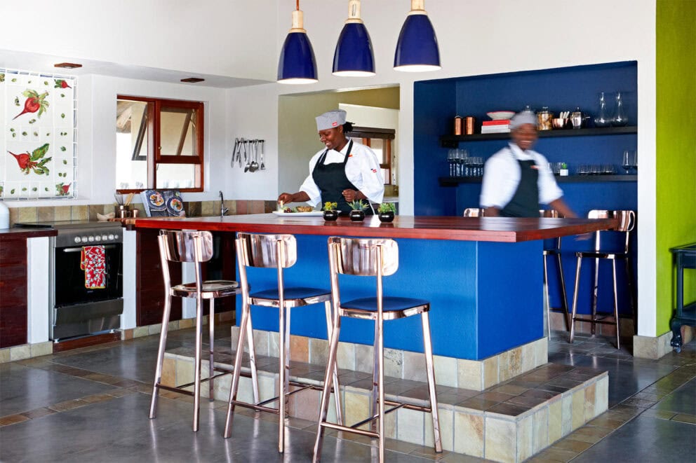 View of the bright blue open kitchen with a private chef at Jaci's Sabi House.