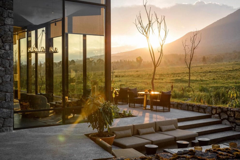 Sunrise view of the outdoor dining area overlooking the Volcanoes National Park landscape at Singita Kwitonda Lodge, Rwanda.