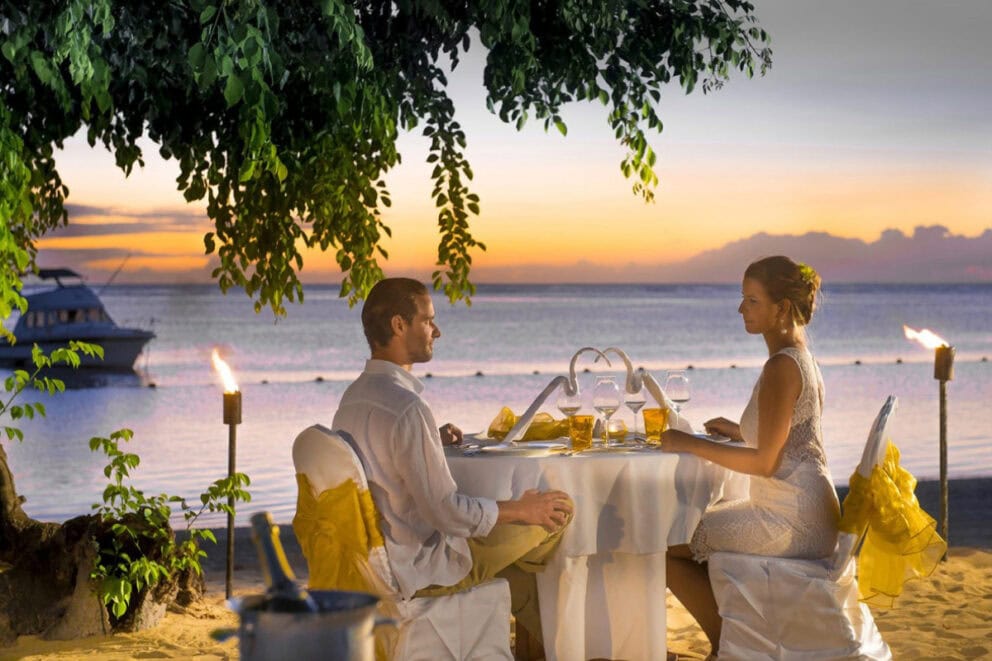A couple having a romantic dinner on the beach at Sofitel Mauritius L'Impérial Resort & Spa, Mauritius.