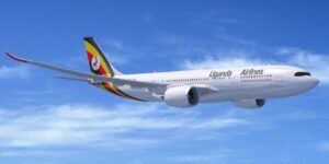 Uganda Airlines plane flying across blue sky