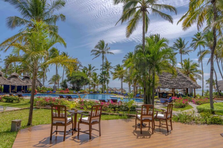 View of the pool-side seating area, featuring tables and chairs at Breezes Beach Club and Spa, Zanzibar