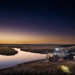 Guests on a night drive in a safari vehicle near Linyanti Expeditions in the Linyanti Concession, Botswana.