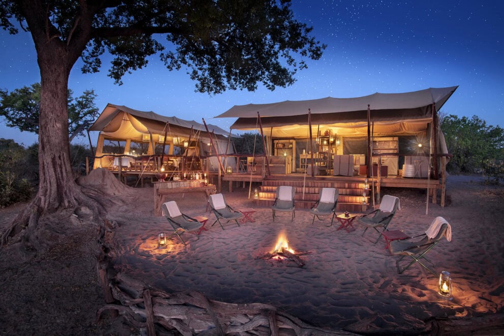 A safari camp in Botswana, campfire surrounded by chairs. 