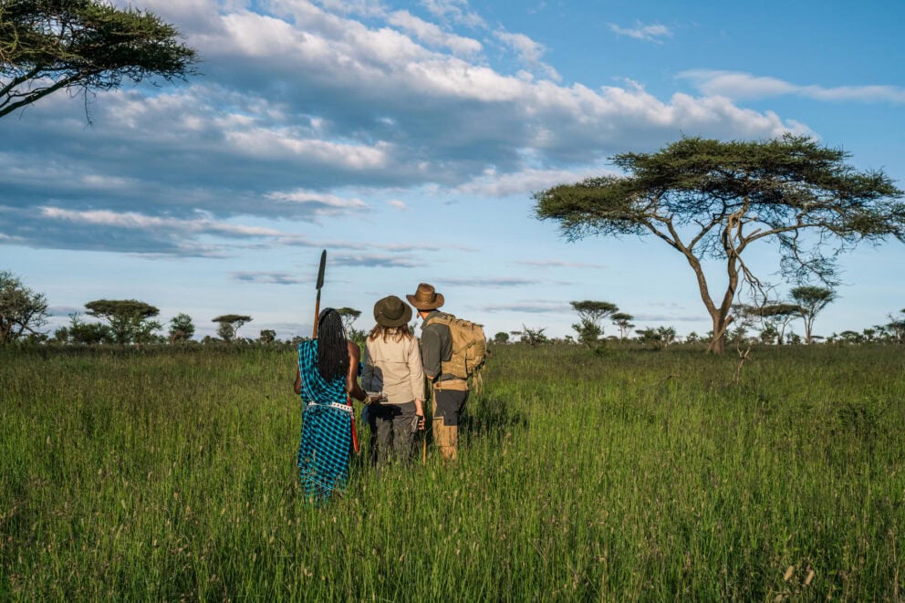 Guests on a guided nature walk with a Maasai guide near Lemala Osonjoi Lodge on the Ngorongoro Crater Rim, Tanzania.