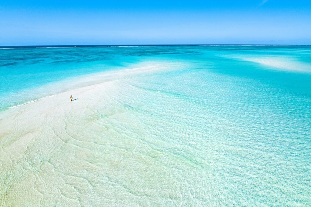 Aerial view of woman walking on sandbank on Nungwi Beach, Zanzibar