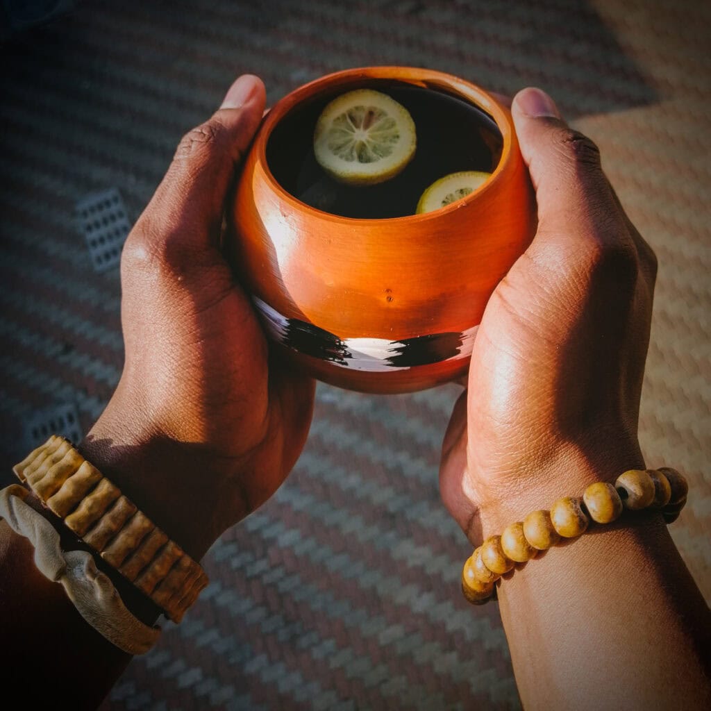 A person holding a holding umancishana or small bowl