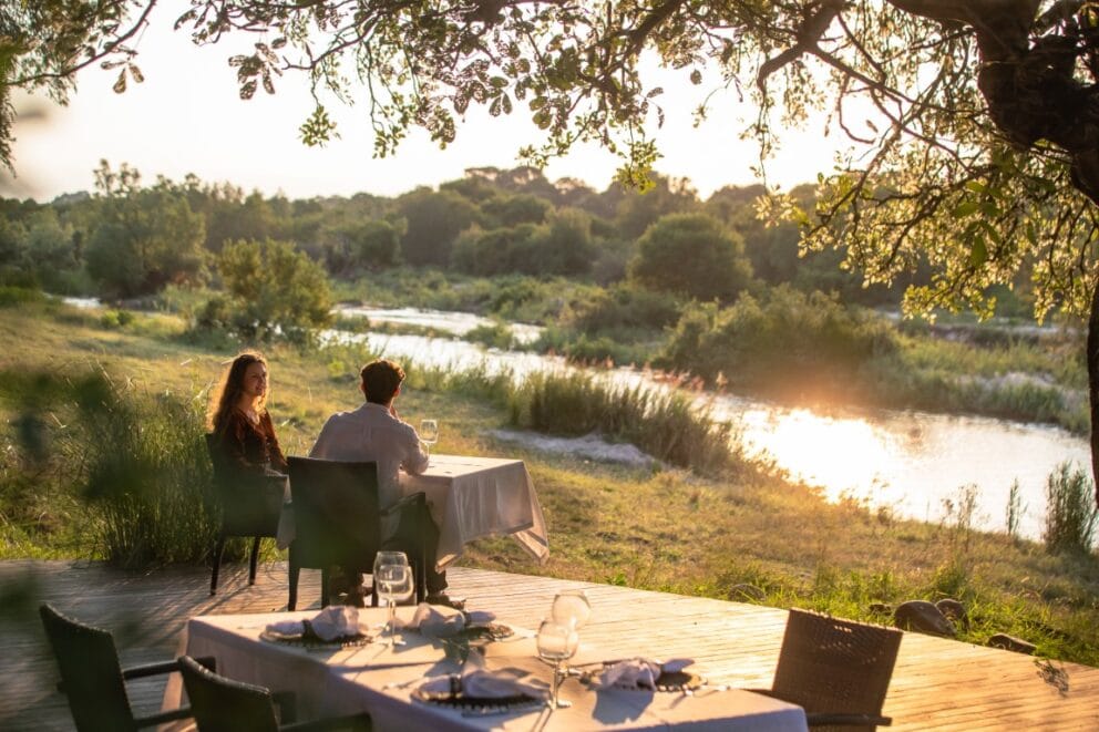 A couple enjoying a private dinner at Dulini River in Sabi Sands Nature Reserve, South Africa.